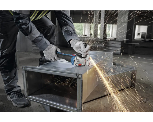 Hantverkare slipar metall med en vinkelslip, gnistor flyger.