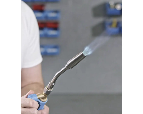 Hand som håller en lödlampa med låga.