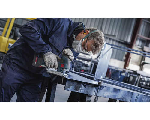 En hantverkare skär metall med en sticksåg i en verkstad.