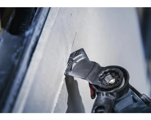 Oscillerande elverktyg skär i en yta.