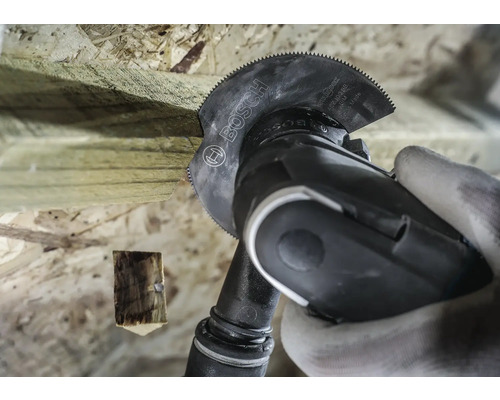 Oscillerande verktyg med sågblad som skär trä. Bosch logotyp