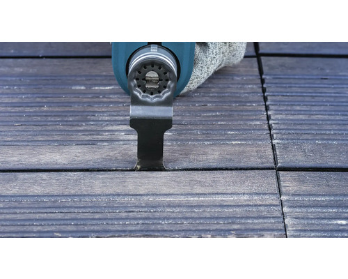 Oscillerande elverktyg skär en fog i trädgårdsplattor