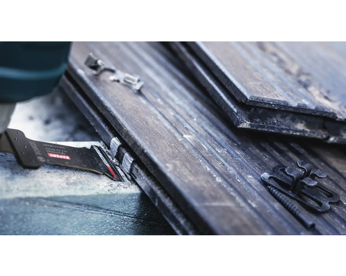 Närbild av ett sågblad som sågar takpannor med fästklämmor