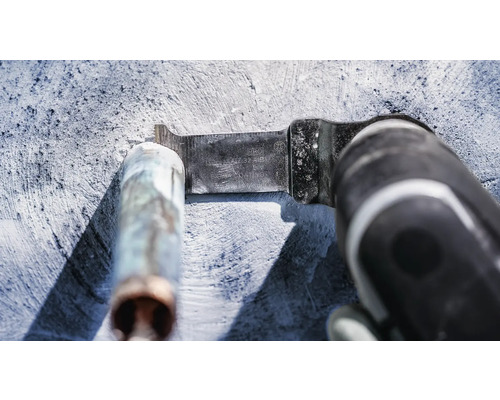 Multiverktyg med metallsågblad som skär ett metallrör