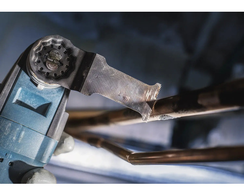 Oscillerande multifunktionsverktyg skär ett kopparrör.