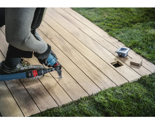 Hantverkare bearbetar en träterrass med ett multifunktionsverktyg