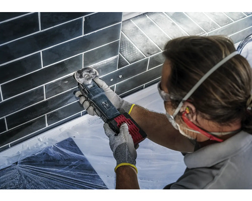 Hantverkare som bearbetar kakelfogar med ett multifunktionsverktyg