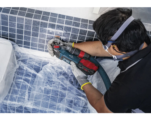 Kakelrenovering med ett multifunktionellt verktyg på en vägg