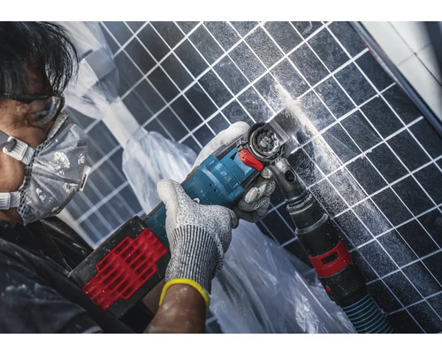 Man arbetar med ett multifunktionellt verktyg på kakel