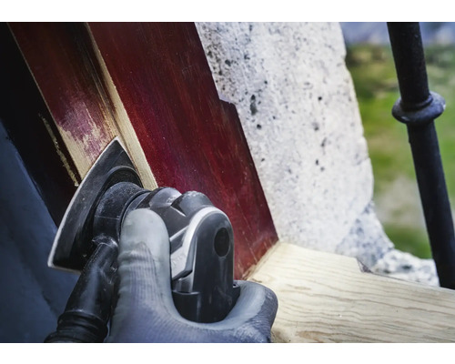 En person slipar trä med en deltaslipmaskin.