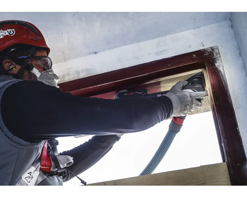 Hantverkare renoverar fönsterkarm med ett multifunktionsverktyg