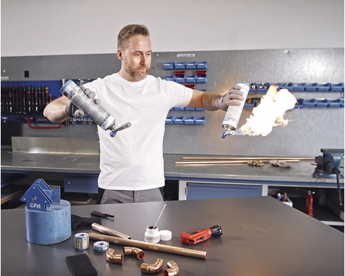 Man som löder kopparrör med en gasbrännare