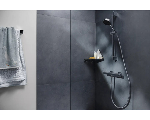 Modernt badrum med dusch, hylla och handdukar