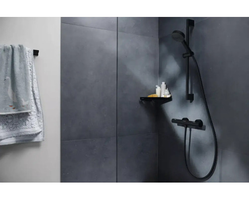 Badrum med dusch, hylla och handduk