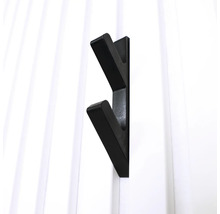 Svart klädkrok på en vit vägg