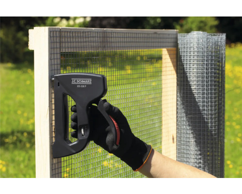 Person fäster trådnät på en träram med en J.C. Schwarz JCS-530 P klammerpistol