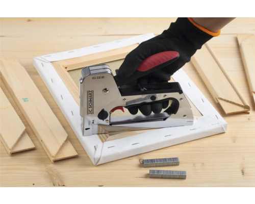 Hand med häftpistol på dukram