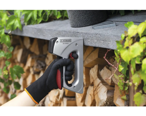 En hand använder en J.C. SCHWARZ häftpistol för att fästa klamrar.