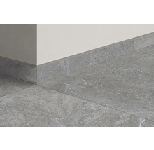 Grå golvplattor och golvlister mot en vägg