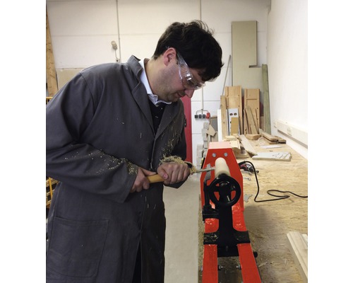 En man arbetar med en svarv för träbearbetning.