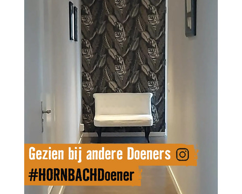 Hall med mönstrad tapet, bänk och fotoramar