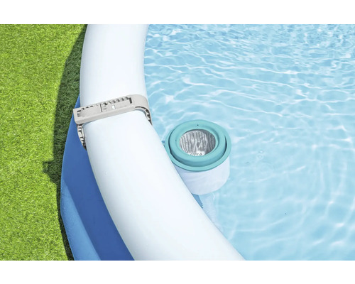 Närbild av en pool med filterpump och slangklämma i klart vatten.