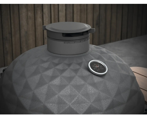 Detaljvy av en kamadogrill med temperaturindikator och strukturerad keramisk yta