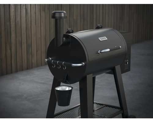 Svart pelletgrill med avgasrör, handtag, krokar och hink