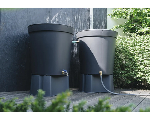 Två mörkgrå regnvattentunnor med kran på en träterrass