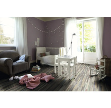 Ljust barnrum med barnsäng, bord, stolar, fåtölj och trägolv