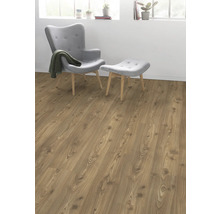 Vardagsrum med laminatgolv i träutseende, fåtölj och fotpall