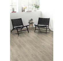 Två svarta rottingfåtöljer och ett sidobord med vaser i ett ljust rum