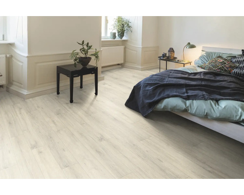 Ljust sovrum med laminatgolv, säng och nattduksbord