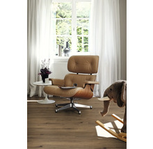 Vardagsrum med fåtölj, bord, fönster och dekoration