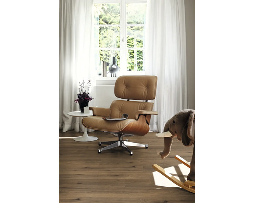 Vardagsrum med fåtölj, bord, fönster och dekoration