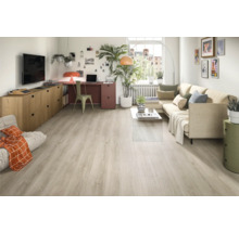 Ljust vardagsrum med soffa, skrivbord och ljust trägolv