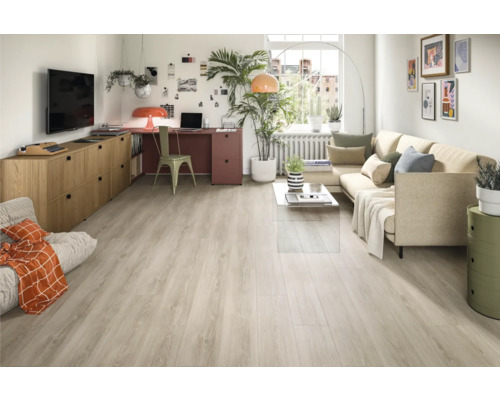 Ljust vardagsrum med soffa, skrivbord och ljust trägolv