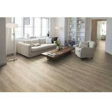 Ljust vardagsrum med trägolv, soffa, fåtölj och bokhylla