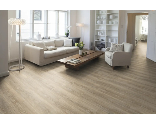 Ljust vardagsrum med trägolv, soffa, fåtölj och bokhylla