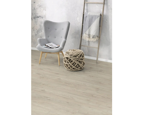 Vardagsrum med fåtölj, stickad boll och trästege med filt på laminatgolv