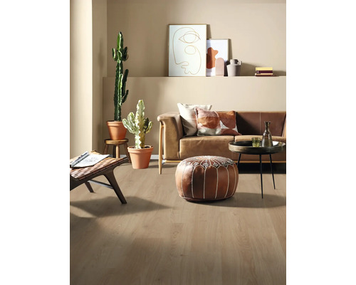 Ljust vardagsrum med soffa, kuddar, växter och trägolv