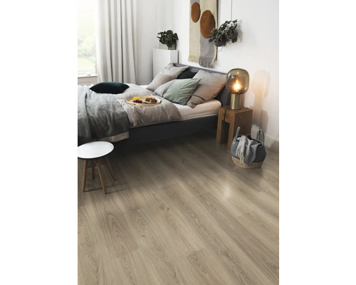 Ljust laminatgolv i ett sovrum med säng, sängbord och dekorationer.