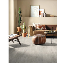 Vardagsrum med ljusgrått laminatgolv, soffa, bord och dekorationer.