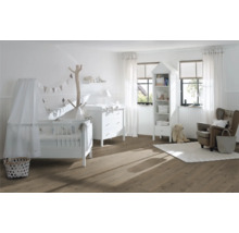 Ljust barnrum med spjälsäng, skötbord, hylla och fåtölj