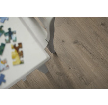 Närbild av laminatgolv med träutseende och vitt bordsben