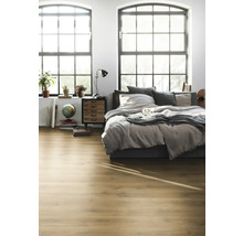 Ljust sovrum med trägolv, säng, nattduksbord och stora fönster