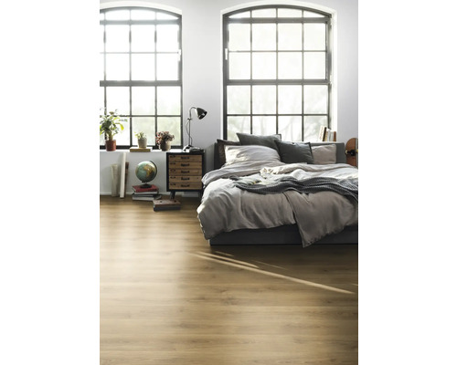 Ljust sovrum med trägolv, säng, nattduksbord och stora fönster