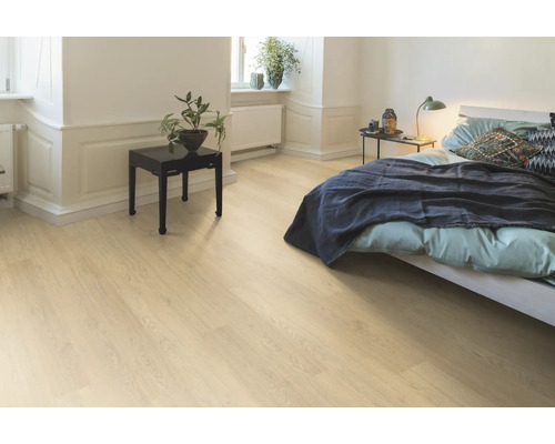 Ljust sovrum med trägolv, säng och sängbord