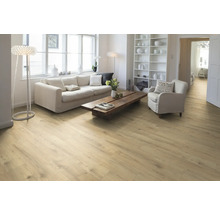 Ljust vardagsrum med trägolv, soffa, fåtölj och hylla.