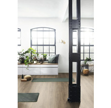 Ljust rum med gymnastikmattor, fönsterparti, växter och en dekorativ stödpelare